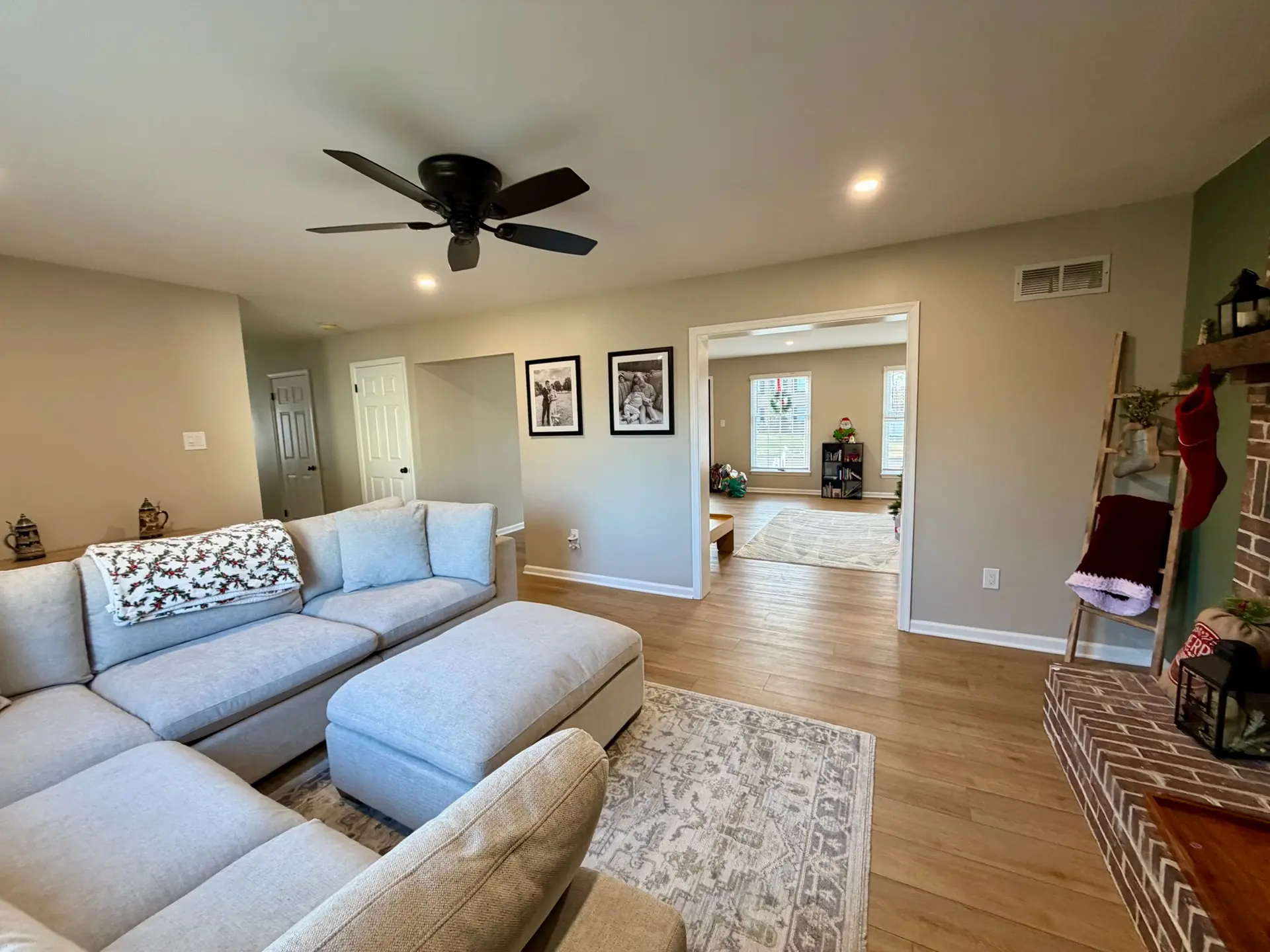 Open living room with new luxury vinyl plank flooring, recessed lighting and a sectional sofa